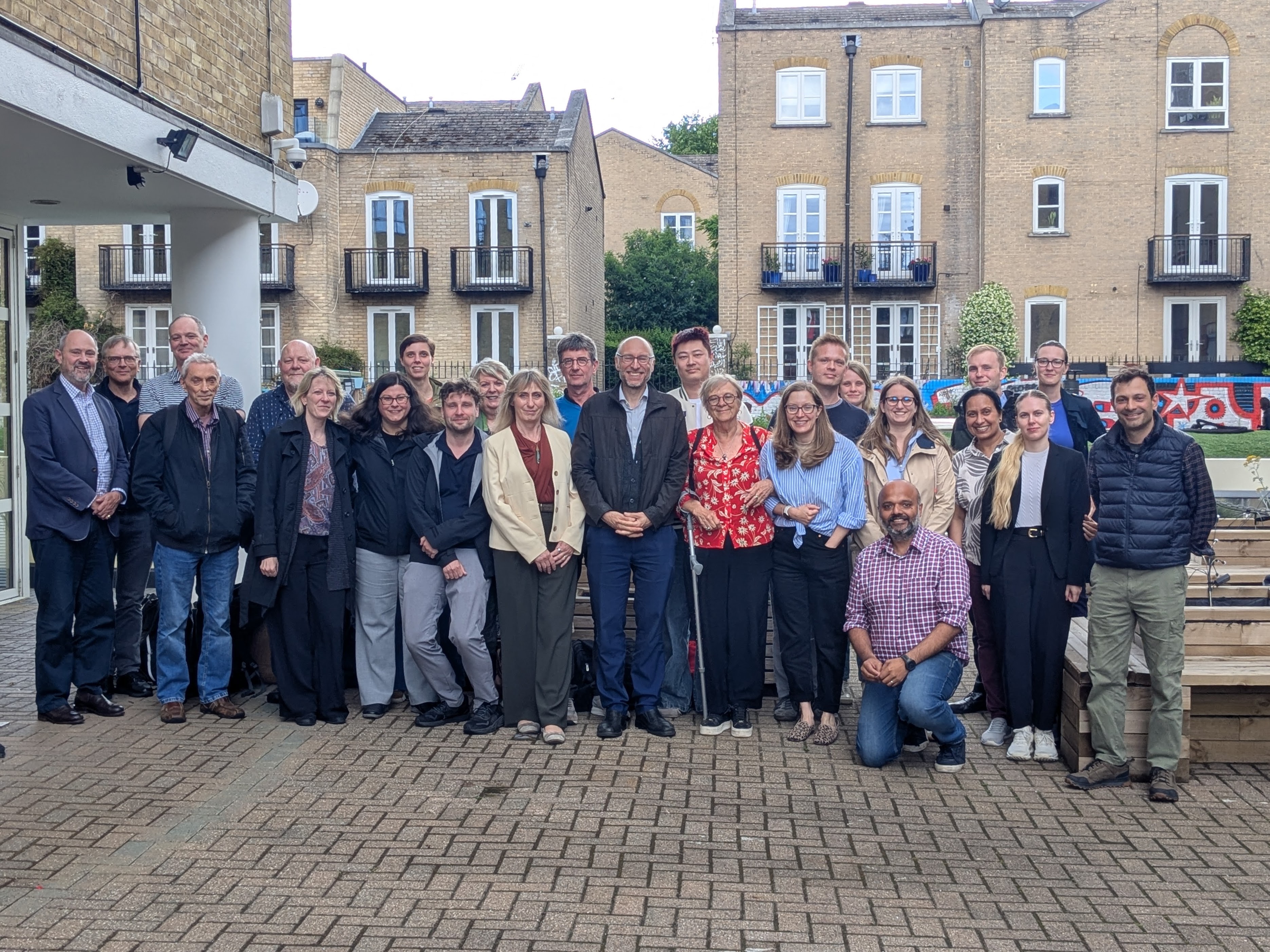 Group photo of the PAINSTORM consortium. About 30 people stand by a London canal, facing the camera, on a sadly not very sunny day.